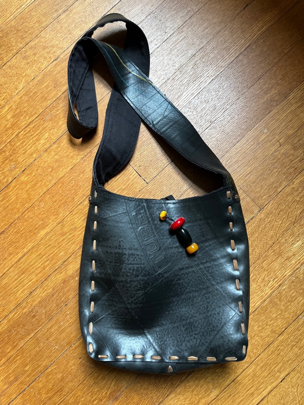 Upcycled Black Rubber Crossbody Bag with Contrast Stitching and Bead Accent